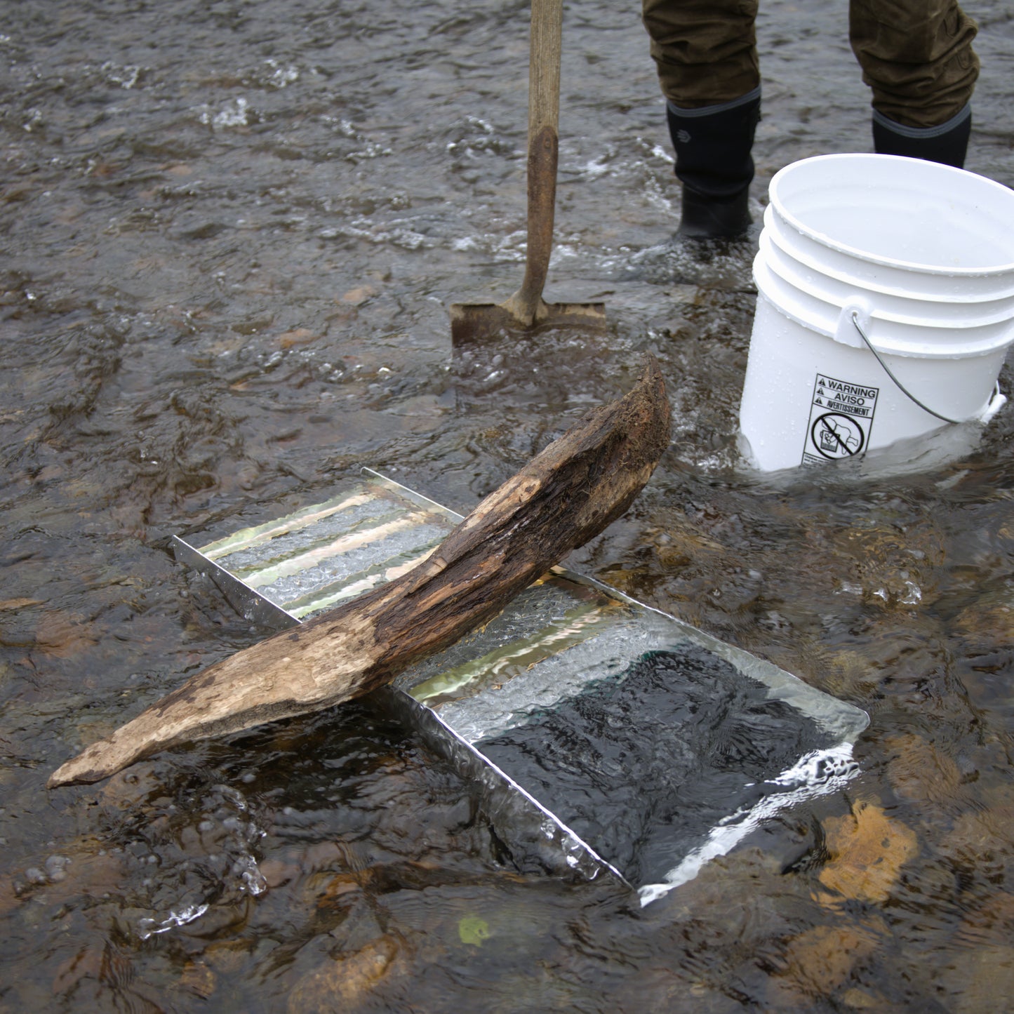 Metal Sluice Box in water with a person gold panning