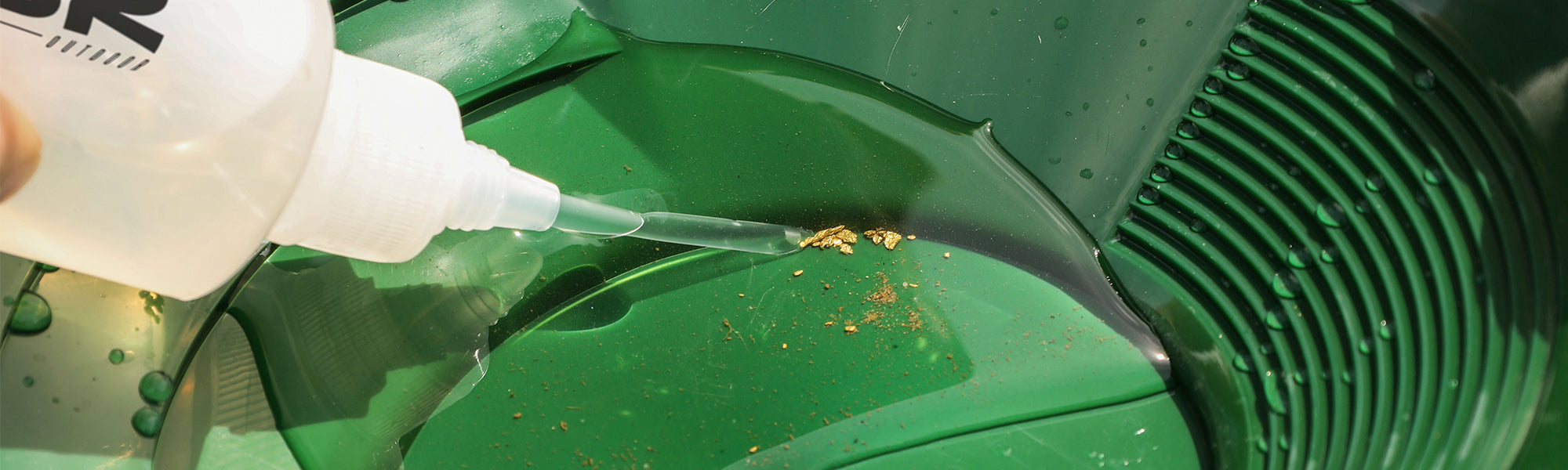 Collecting gold flakes in a gold pan golden nuggets panning for gold