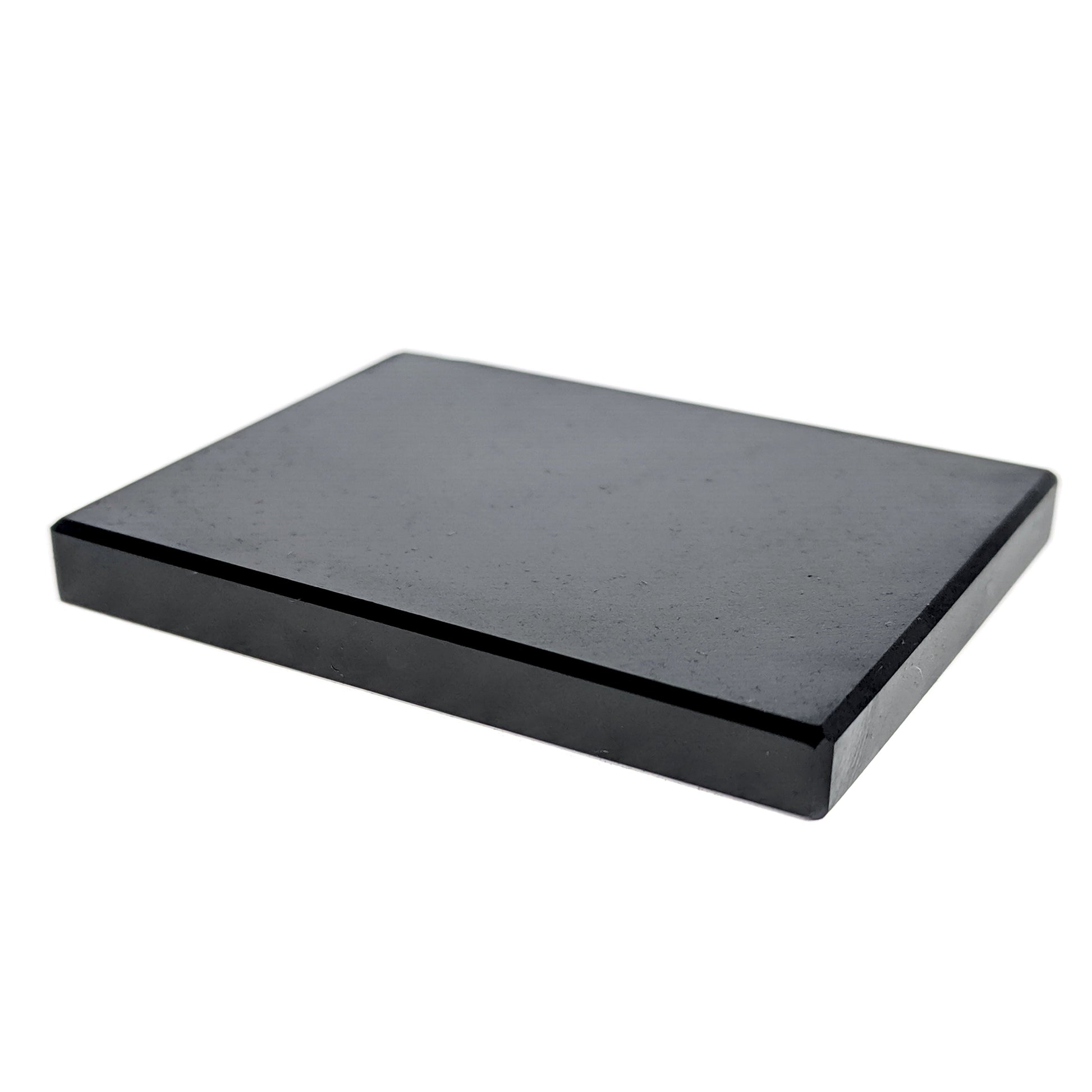 A black, rectangular testing stone used for prospecting and determining the precious metal content of a metal.