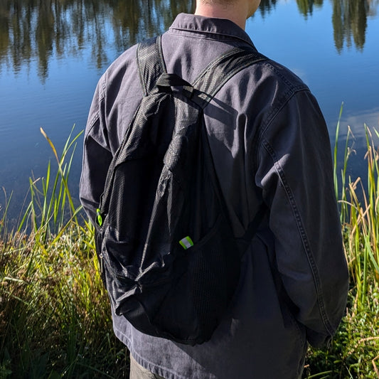collapsible all black backpack transforms from as small as a pencil pouch to a medium sized backpack