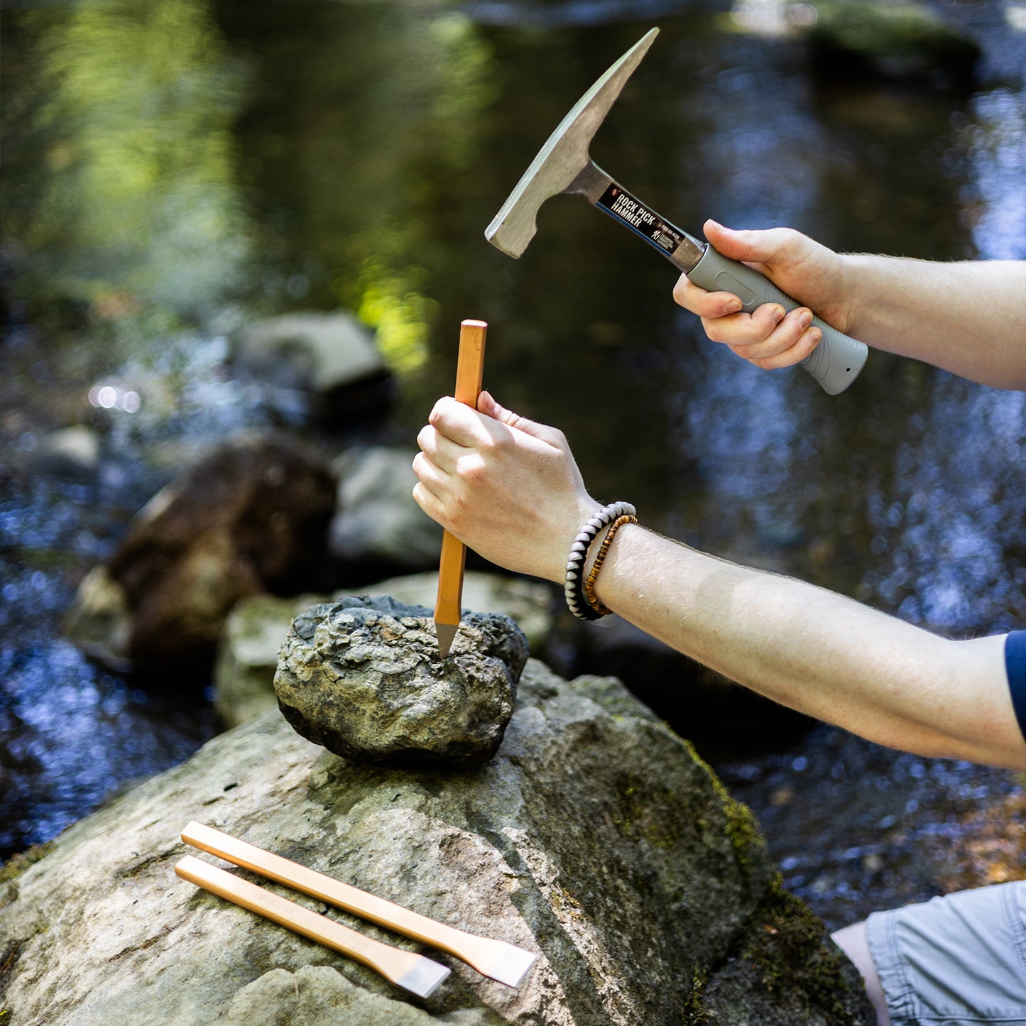 Cracking open a rock with a geology hammer and chisel set