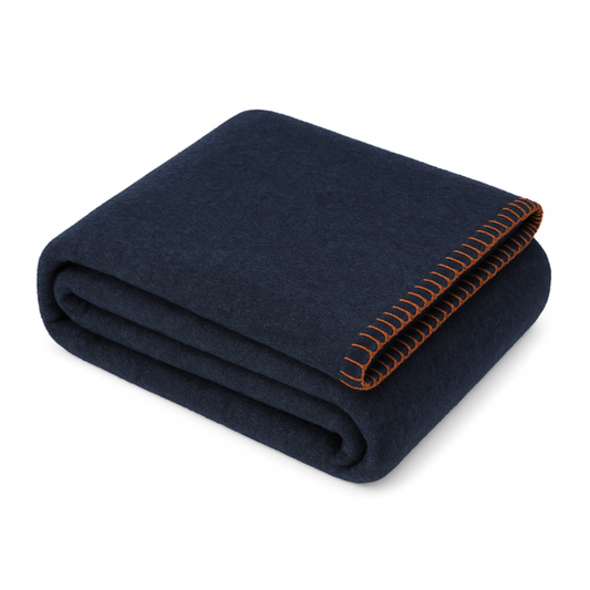 Folded navy blanket with orange stitching on a white background