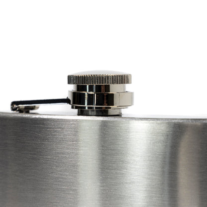 Close-up of a silver flask with a cap on a white background