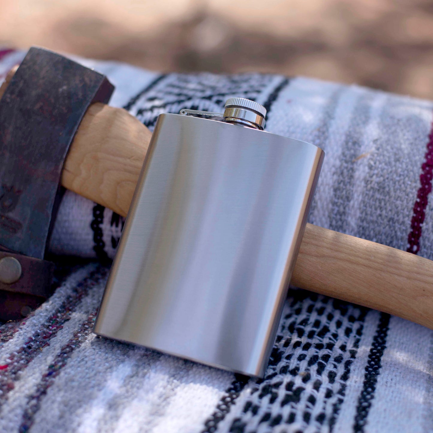 Stainless steel flask on a patterned fabric surface with a blurred background