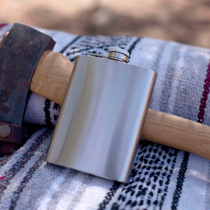 Stainless steel flask on a patterned fabric surface with a blurred background