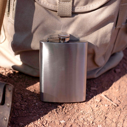 Stainless steel flask on a dirt ground.