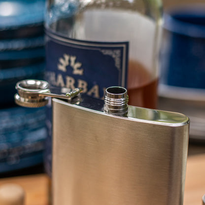 Metallic flask with a blurred bottle in the background