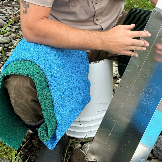 Person cleaning a metal sluice box ready to add miners moss 